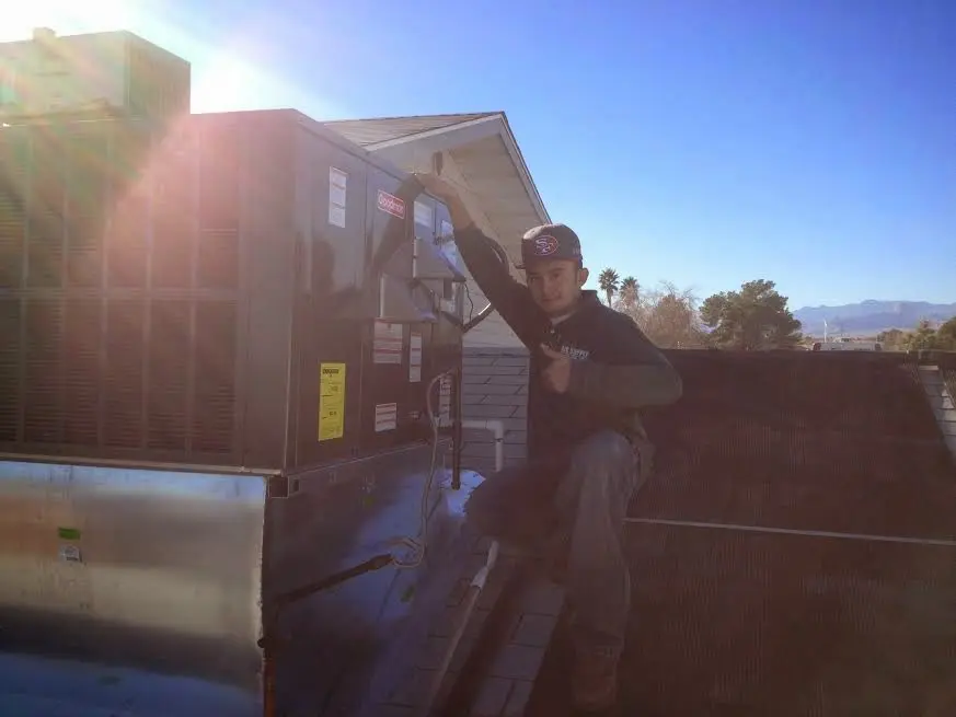 HVAC technician performing Heat Pump Repair on a rooftop unit in Berea
