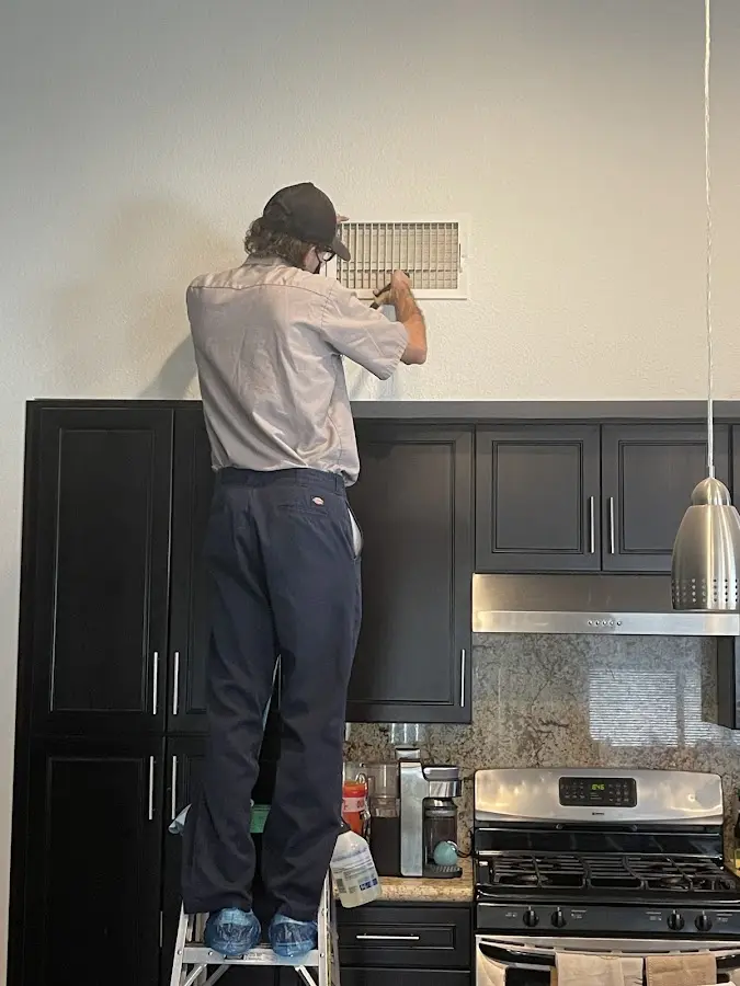 Technician inspecting an air vent during HVAC service in Berea
